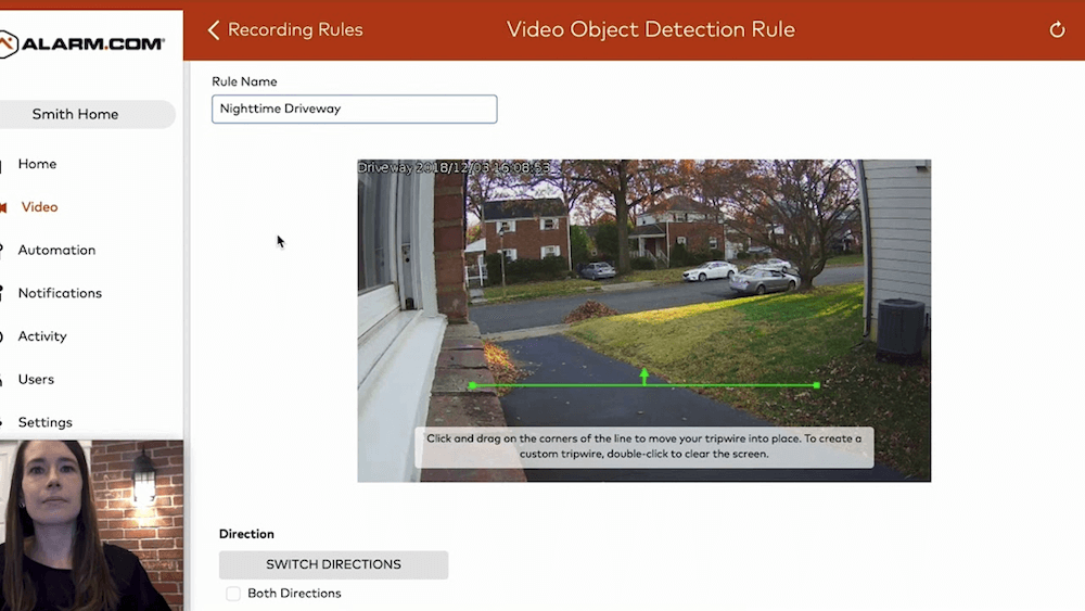 A person is viewing a computer screen showing a surveillance camera setup interface for a house's driveway with video object detection options and instructions.