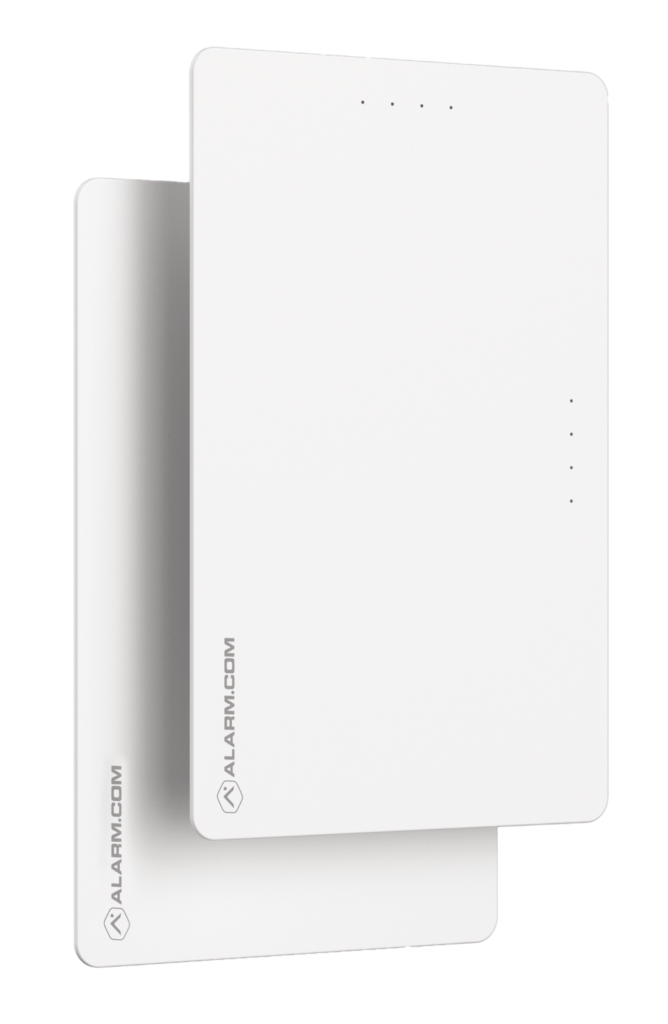 The image shows a sleek, white, rectangular device with rounded corners and a minimal design, branded with "ALARM.COM" on its lower front.