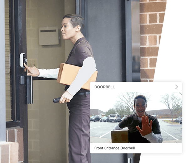A person is delivering a package, pressing a digital doorbell, which displays the image of a smiling person holding a box at the front entrance.