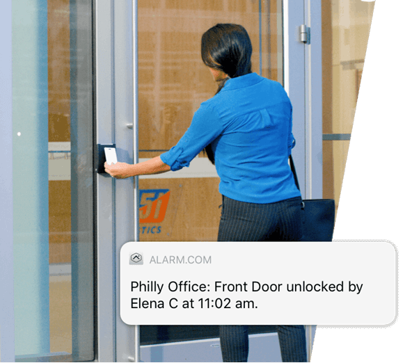 A person in a blue shirt is unlocking a glass door at an office entrance. A notification indicates "Front Door unlocked by Elena C at 11:02 am."