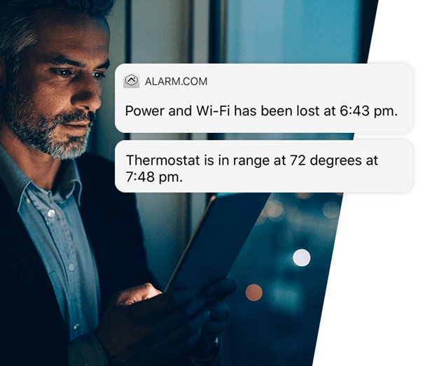 A person looks at a tablet displaying notifications from ALARM.COM about a power and Wi-Fi outage and a thermostat status update.
